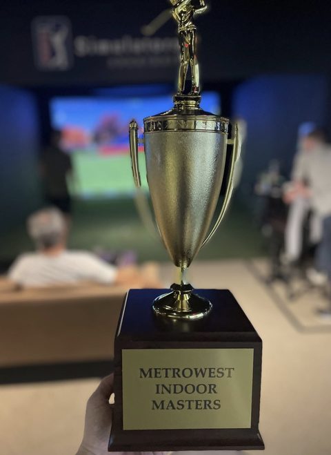 The Metrowest Indoor Masters trophy held up in front of a bay