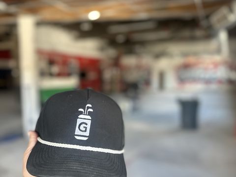 A Dr. Greens cap held up inside the building mid-build